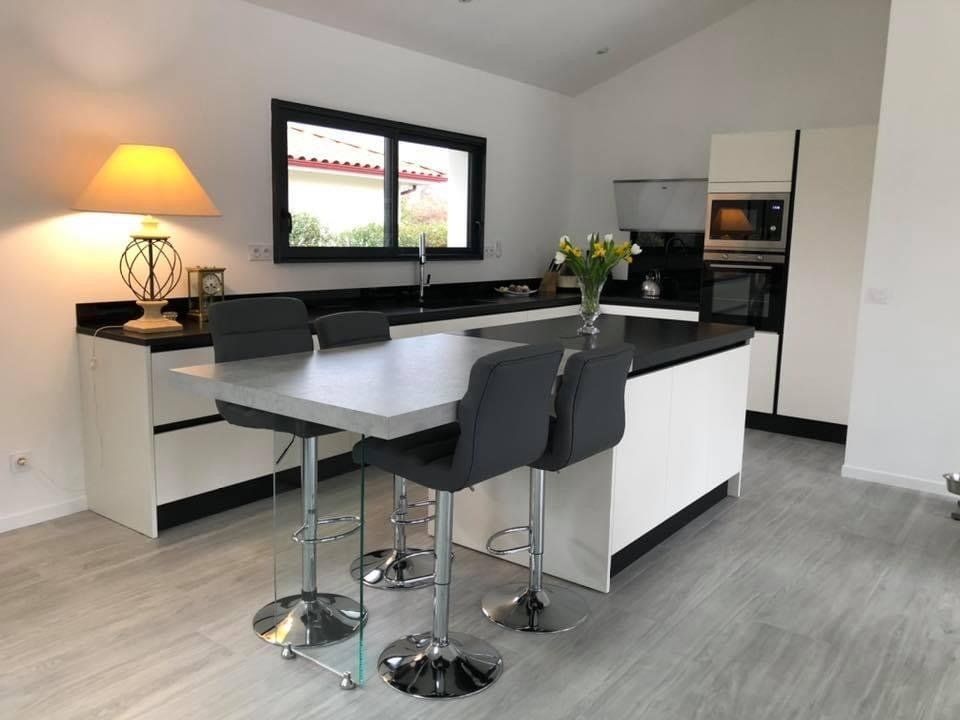 Création d'une cuisine moderne claire et plan de travail noir, avec îlot central