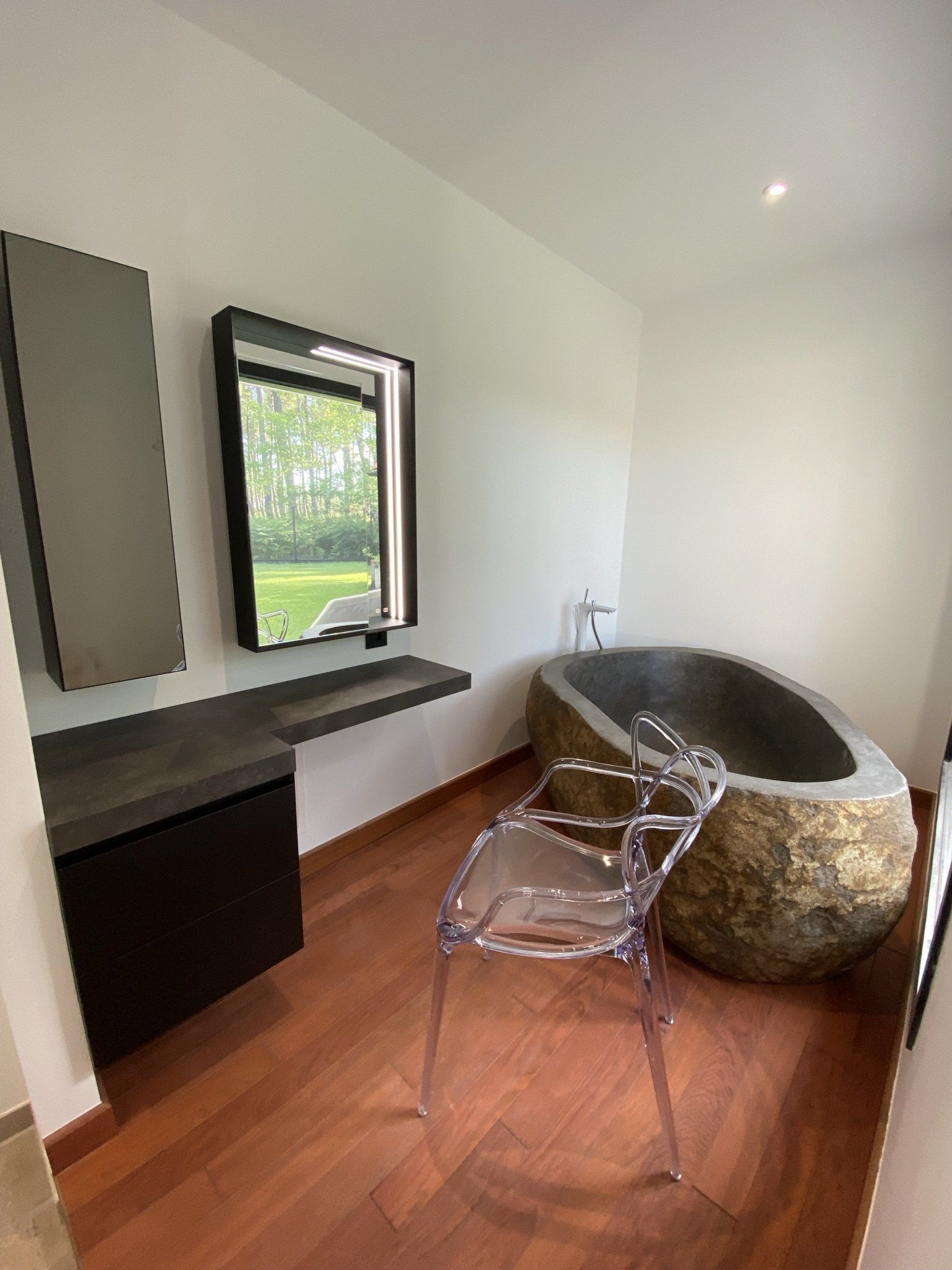 Photo pièce avec grande baignoire taillé dans une pierre, massive