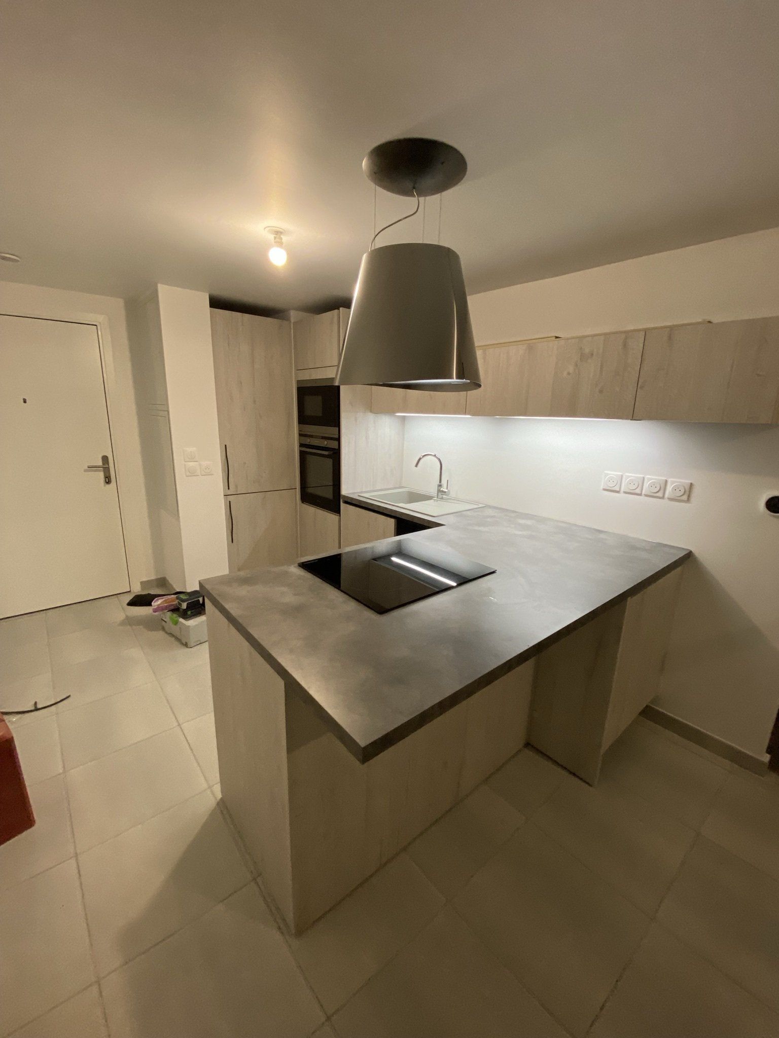 Pose d'une cuisine dans un appartement ; cuisine ouverte et moderne, équipée