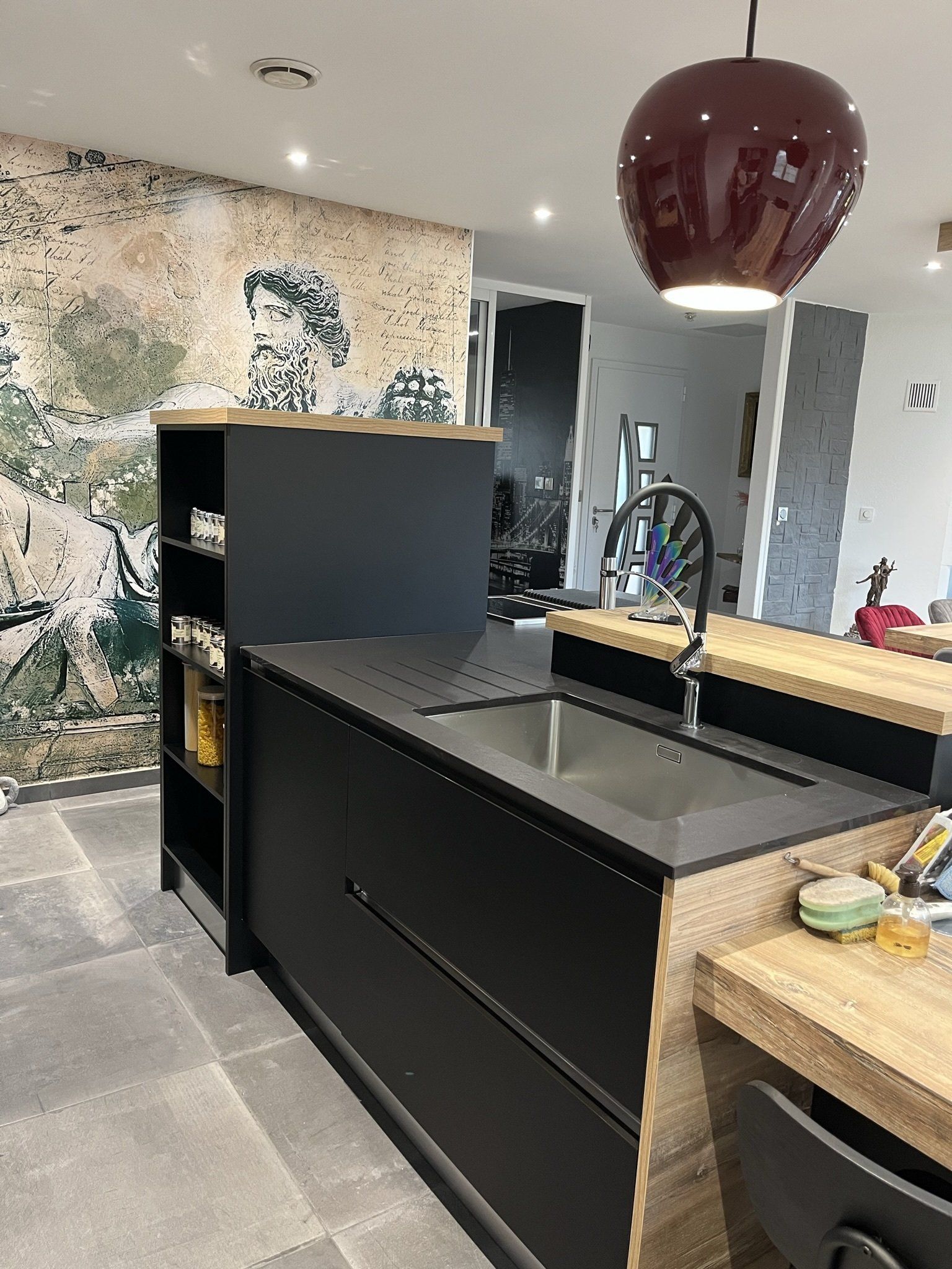 Photo d'un îlot central avec des rangements noir et bois, avec bac évier inox.