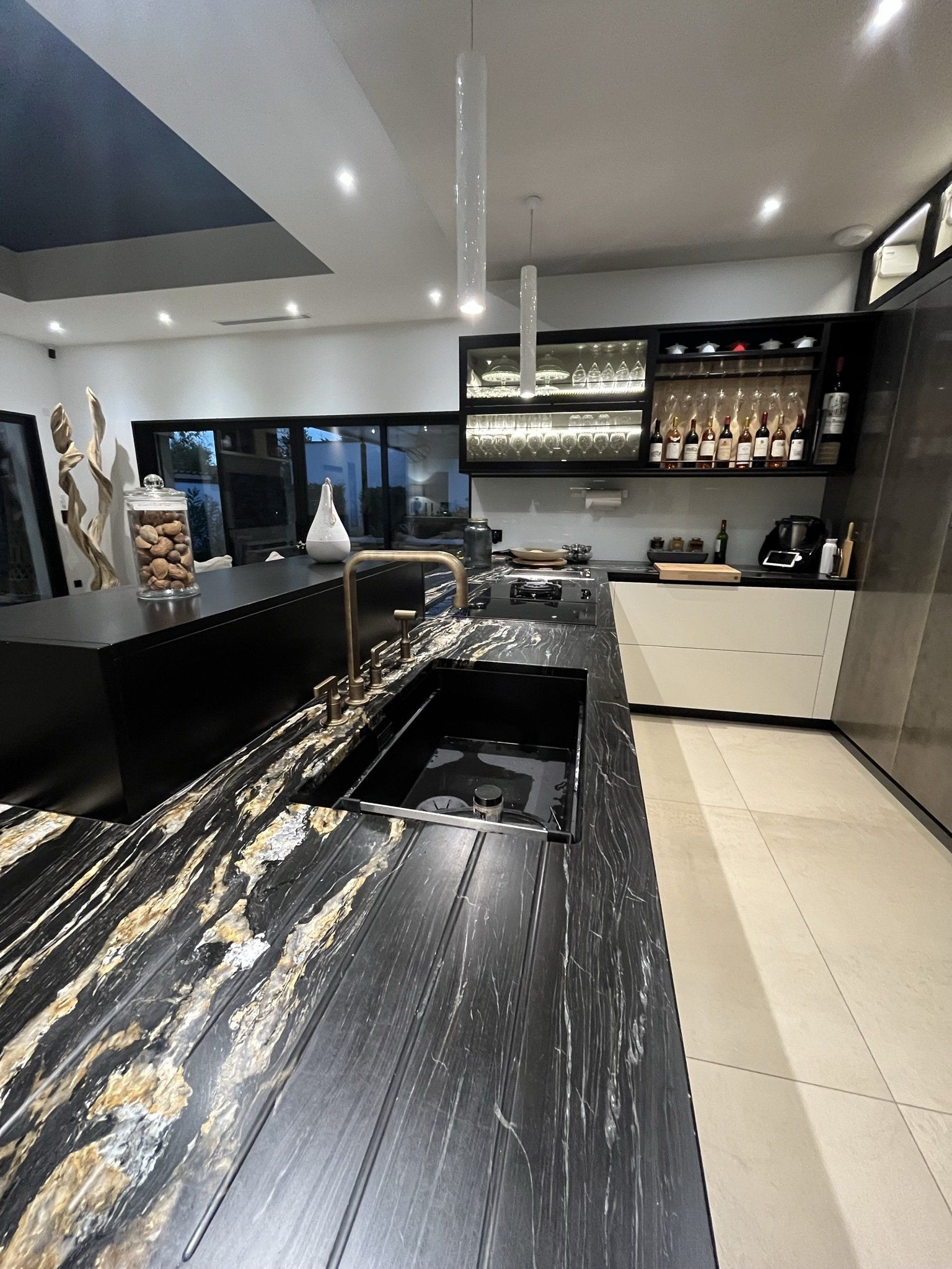 Photo du plan de travail bois noir et marron, grand bac évier dans une cuisine moderne et sobre