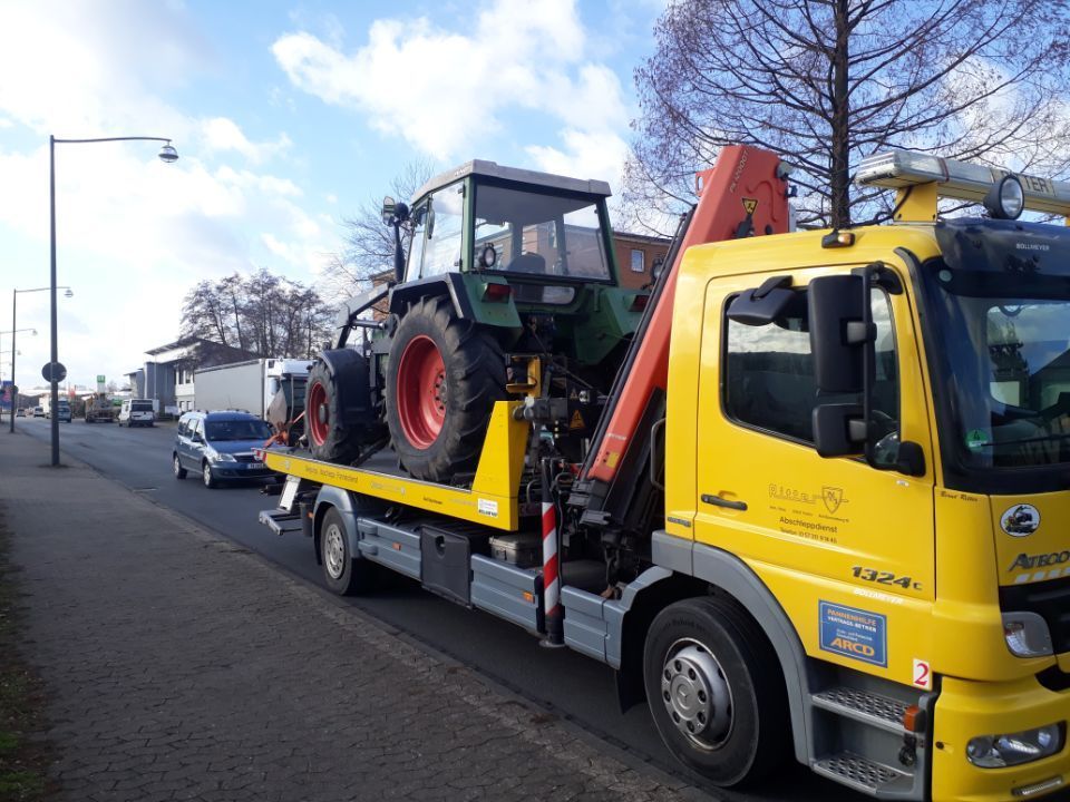 Gelber lKW schleppt Traktor ab