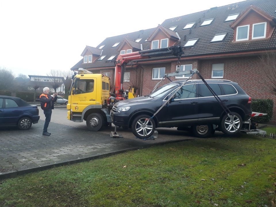 Auto wird vor einem Haus abgeschleppt