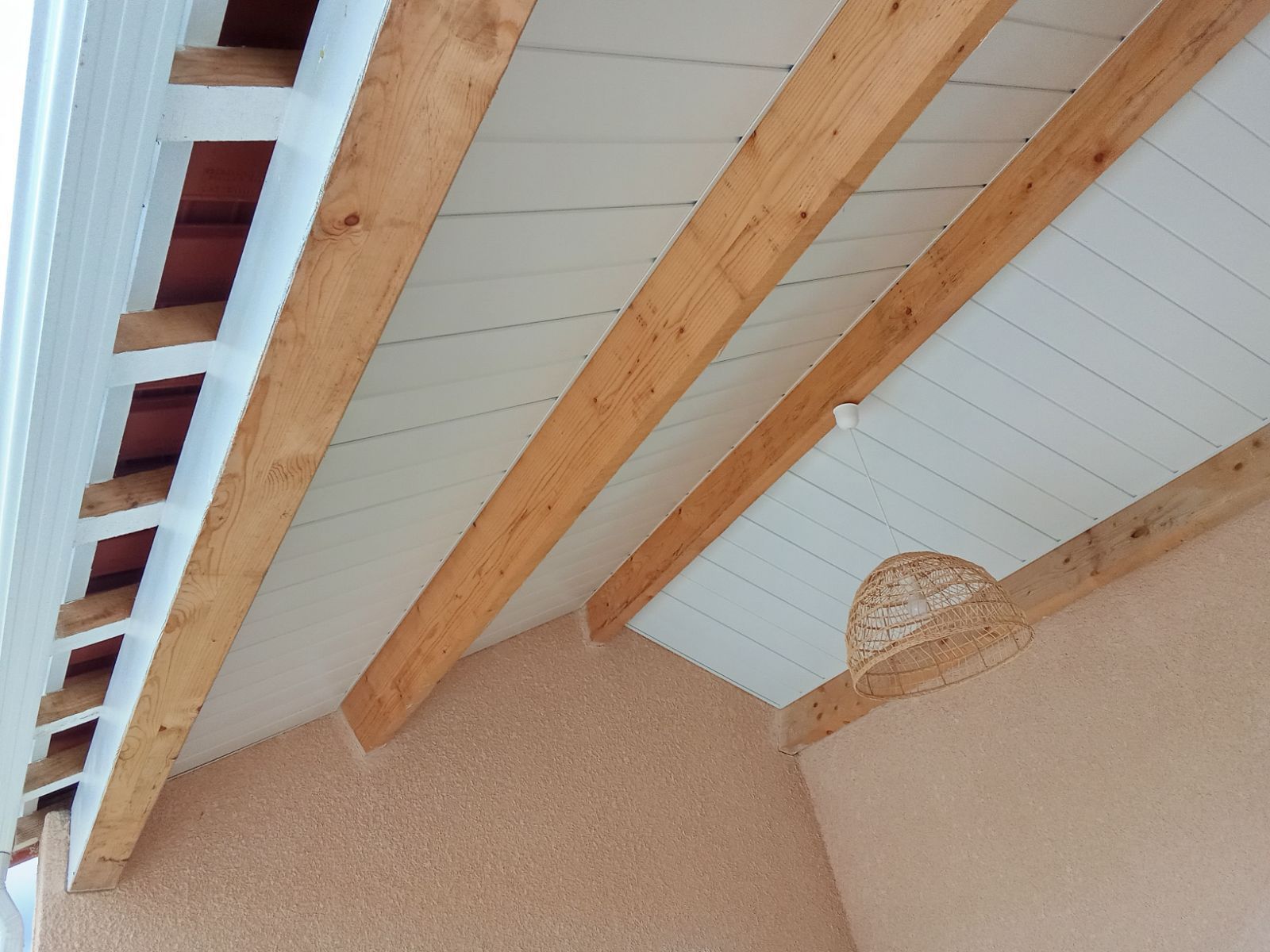 Plafond d'une maison avec recouvrement métallique blanc.