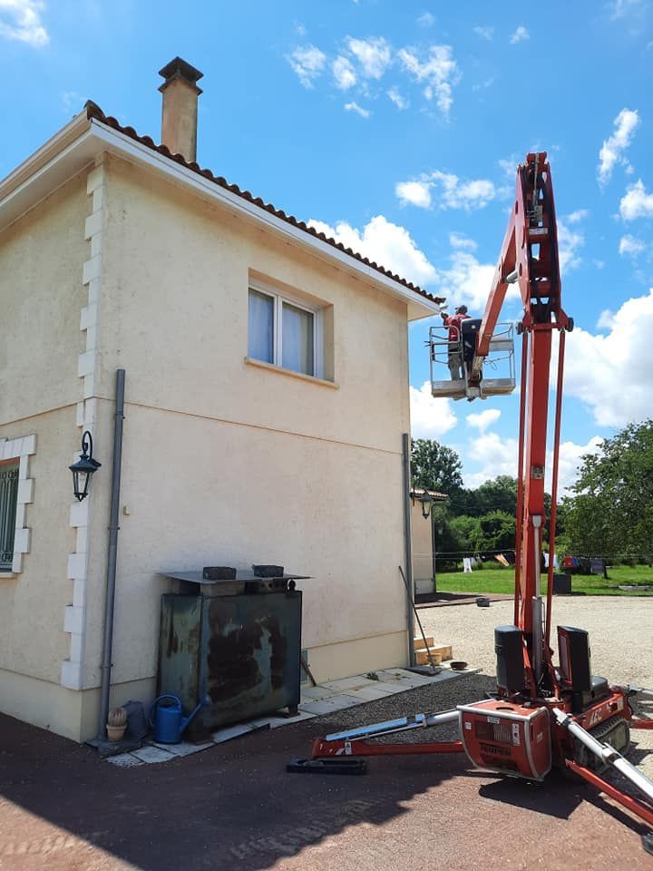 Nacelle rouge avec un professionnel de zinguerie près d'une maison.