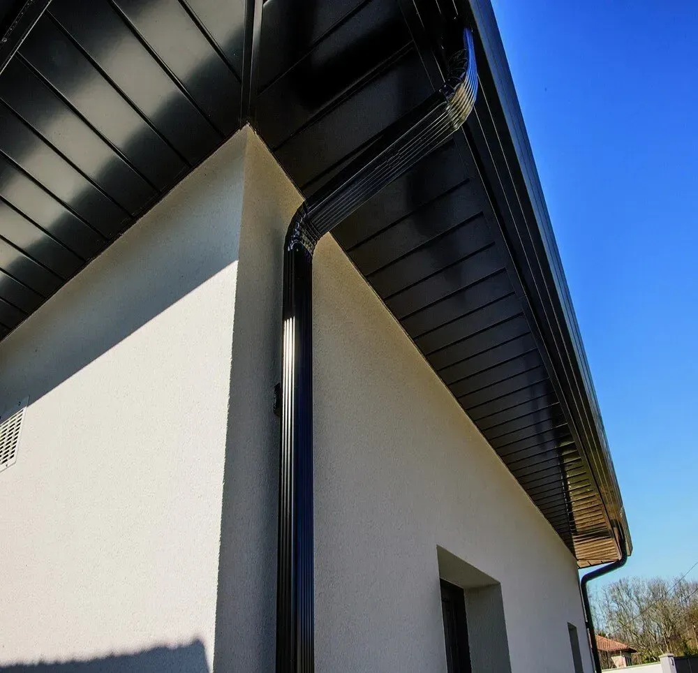 Maison avec gouttière noire.