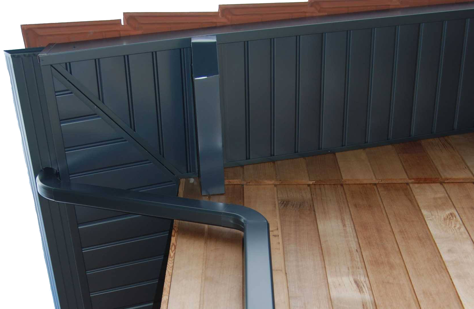 Coin d'une toiture de maison avec une gouttière en aluminium noir.