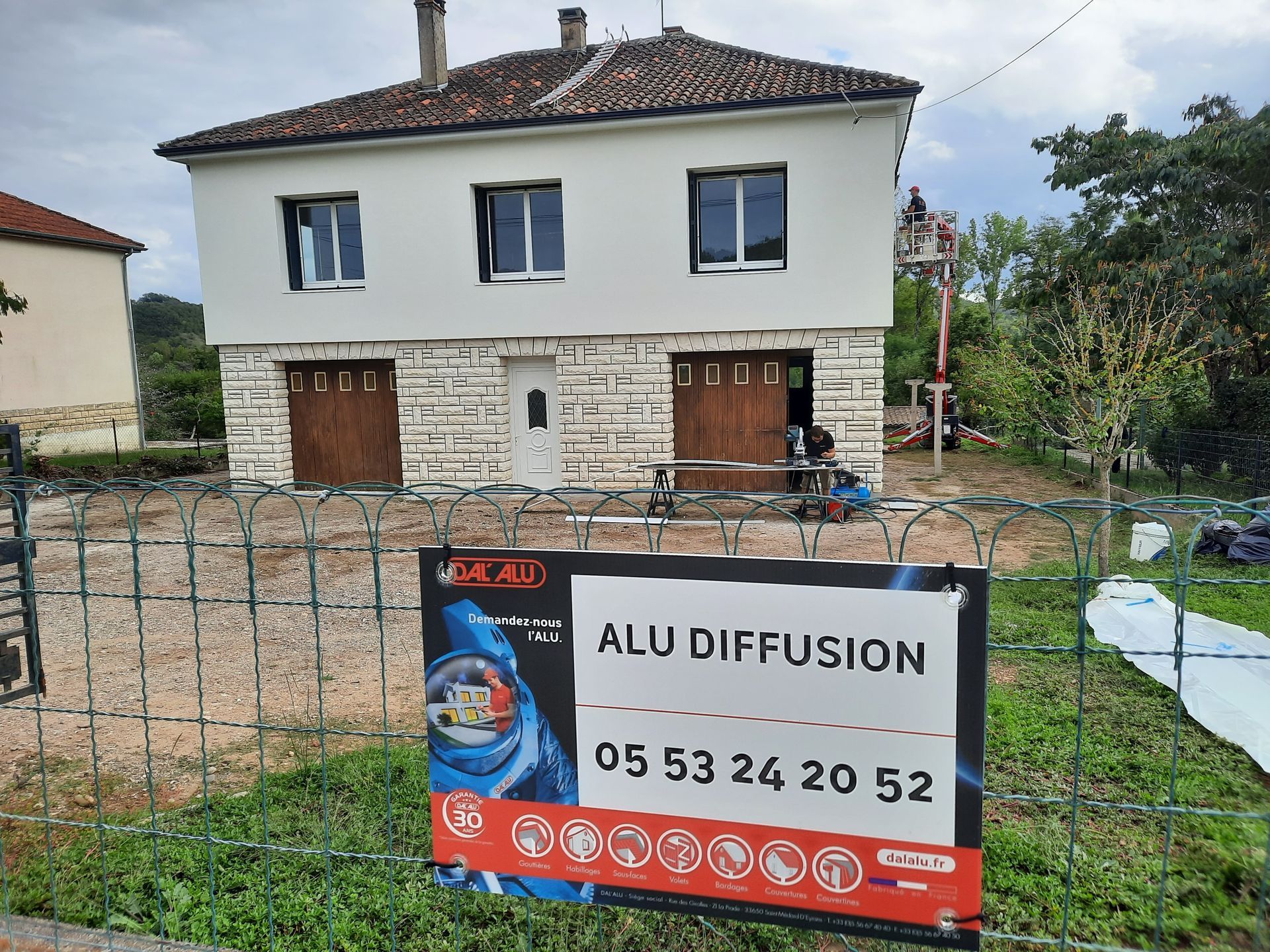 Maison avec un panneau sur son grillage indiquant une intervention de Alu Diffusion.