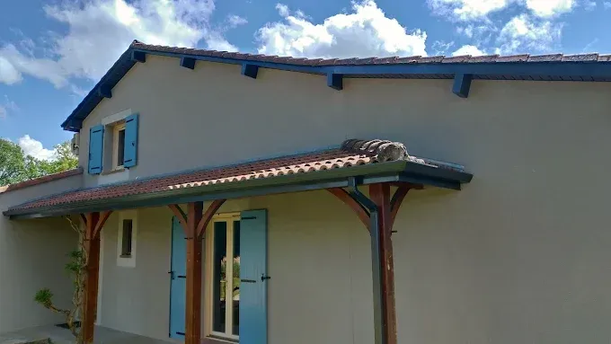 Façade blanche d'une maison avec volets noirs