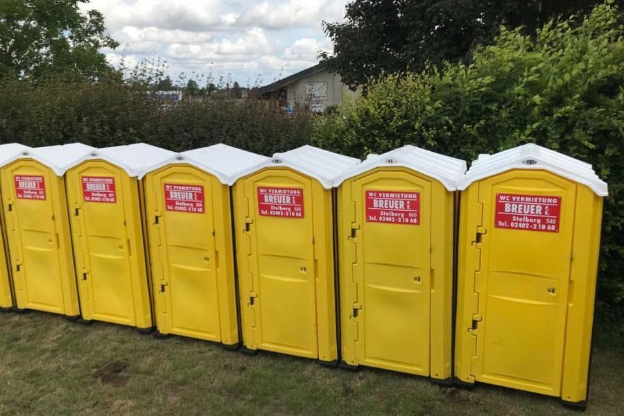 Mehrere gelbe Mobiltoiletten stehen in einer Reihe