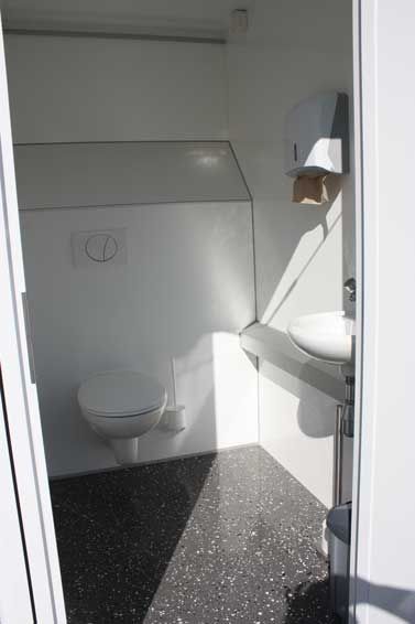 Im Badezimmer gibt es eine Toilette und ein Waschbecken.
