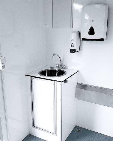 Ein Badezimmer mit Waschbecken und Papierhandtuchspender.