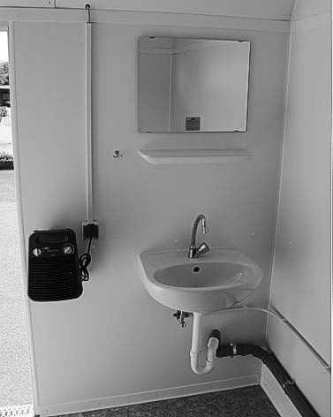 Ein Schwarzweißfoto eines Badezimmers mit Waschbecken und Spiegel.