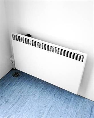 In einem Raum steht ein weißer Heizkörper auf blauem Boden.