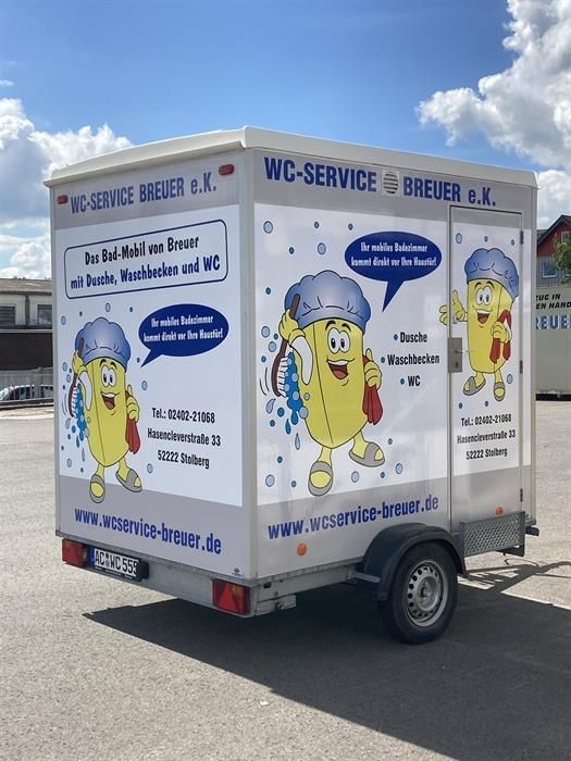 Ein Anhänger mit einer Zeichentrickfigur darauf, auf der steht „WC-Service“