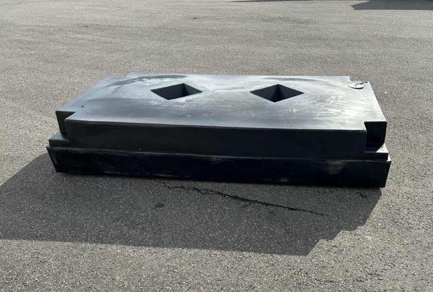 Auf dem Boden liegt ein schwarzer Plastikblock mit zwei quadratischen Löchern.