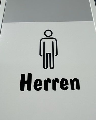 Ein Schild mit der Aufschrift „Herren“ und einem Bild eines Mannes