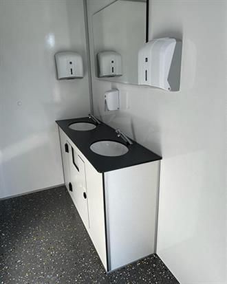 Ein Badezimmer mit zwei Waschbecken und einem Spiegel.