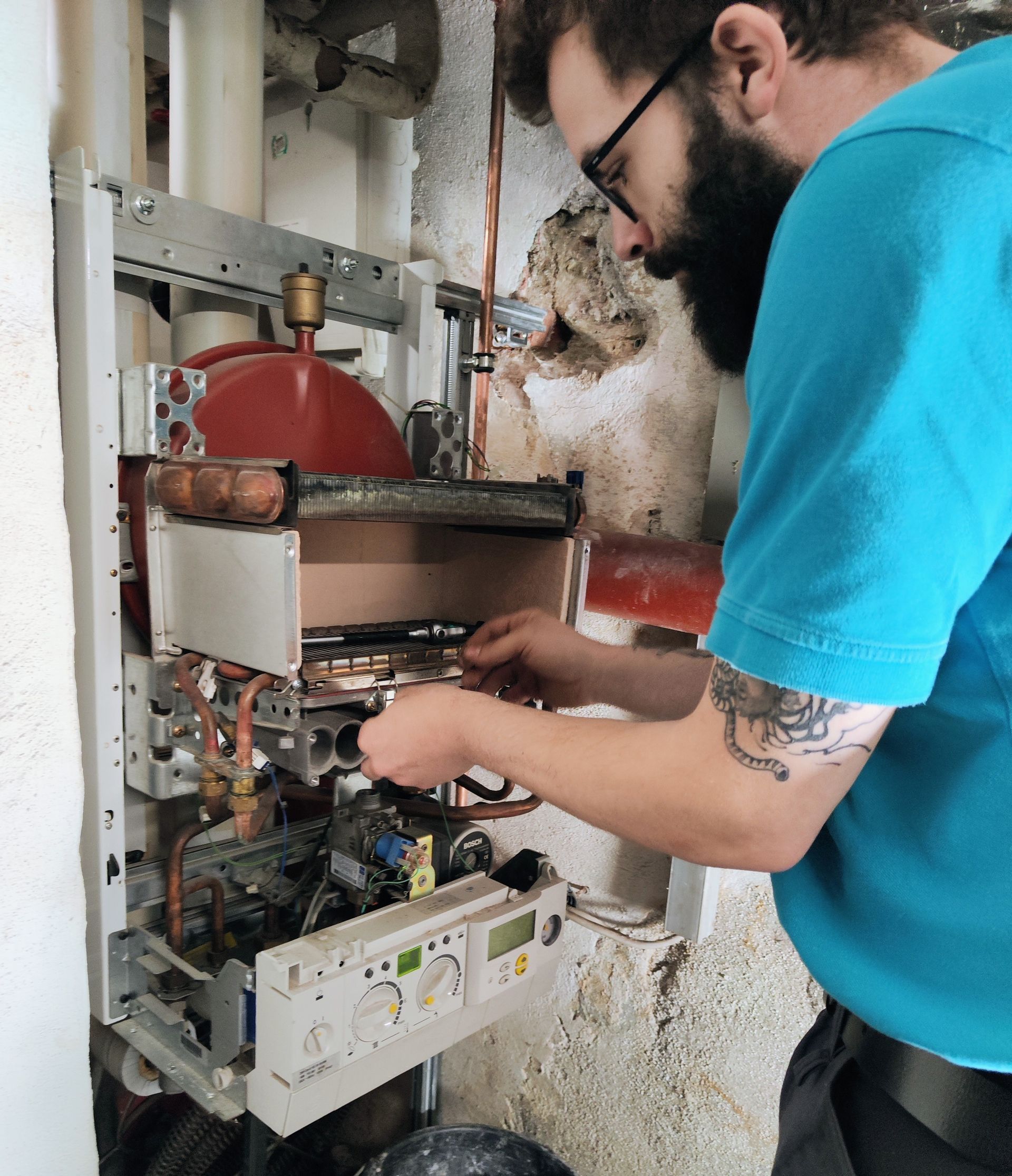Ein Mann in einem blauen Hemd arbeitet an einem Kessel