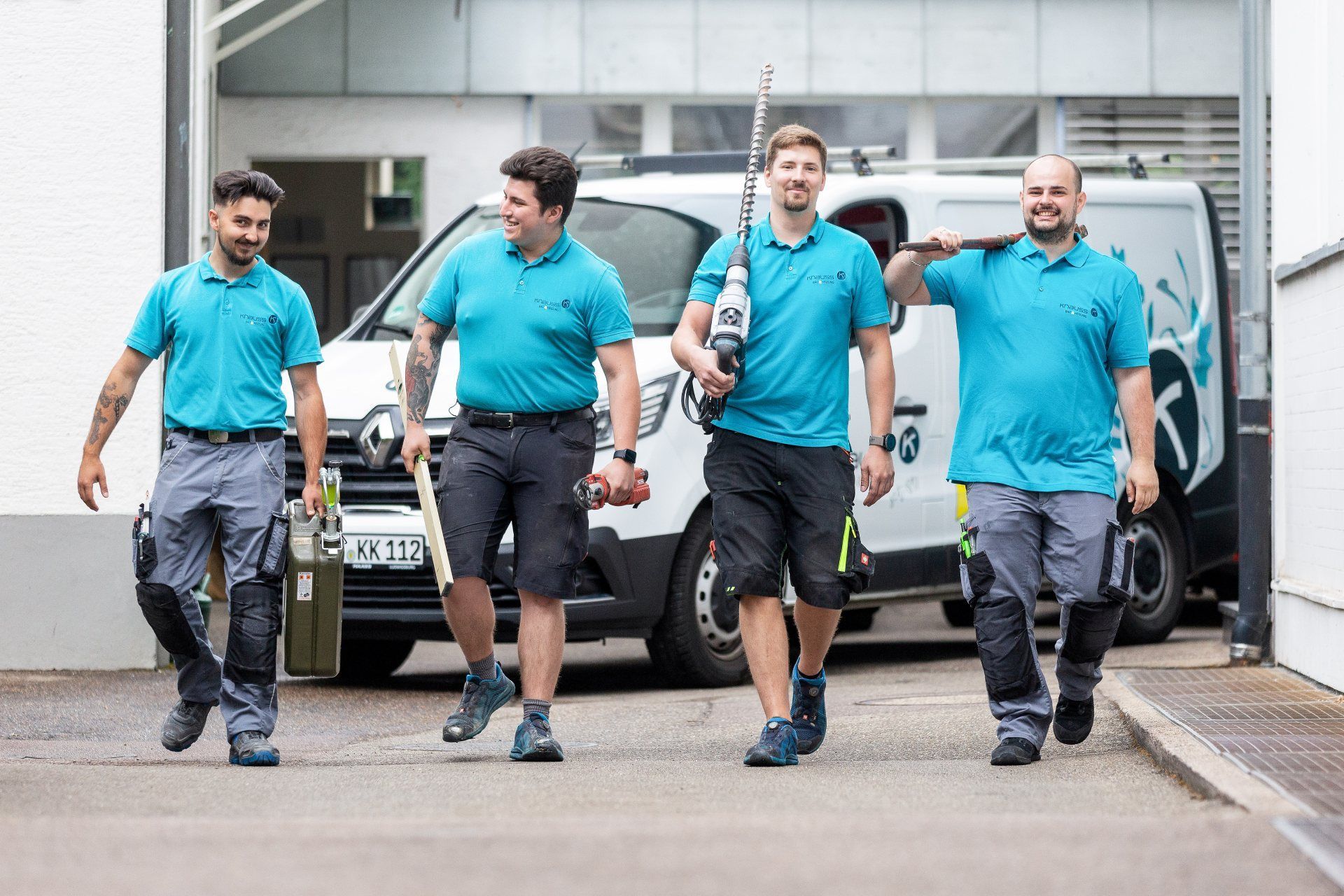 Eine Gruppe Männer läuft mit Werkzeug und Arbeitskleidung.