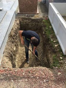 Fossoyeur avec une pelle lors de la réalisation d'une fosse