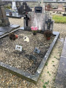 Sépulture avec plaques et décorations funéraires sur gravier