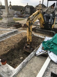 Petite pelle avec conducteur dans le cimetière