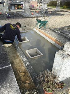 Préparation d'une tombe à la réception d'urnes funéraires