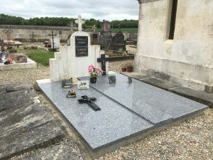 Tombe double en granit avec plaques et fleurs