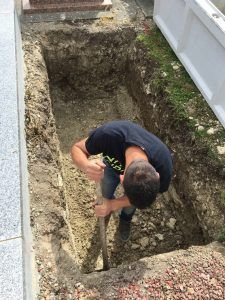 Fossoyeur en train de creuser une tombe