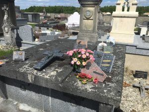 Sépulture ancienne avec plaques et fleurs