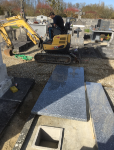 Caveau funéraire avec pelleteuse à l'arrière-plan