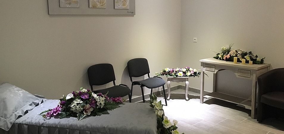 Vue de la chambre funéraire avec fleurs, lit et chaises