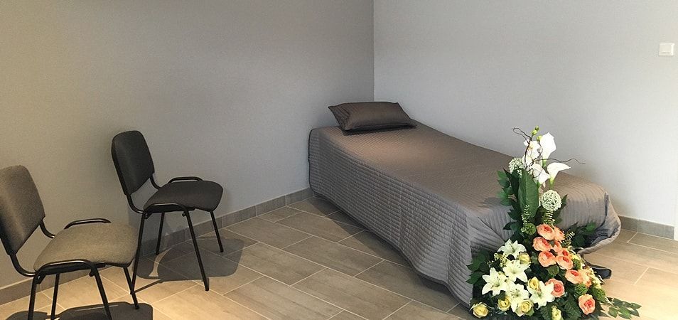 Vue d'un lit et d'une chaise dans la chambre funéraire