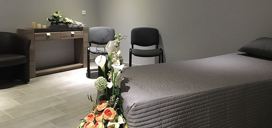 Vue d'un lit et de deux chaises dans la chambre funéraire