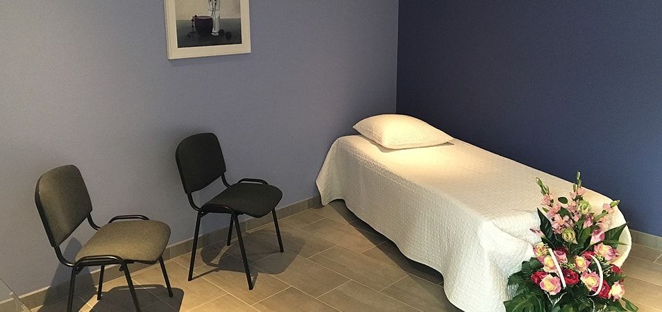 Vue d'un lit avec drap blanc dans la chambre funéraire