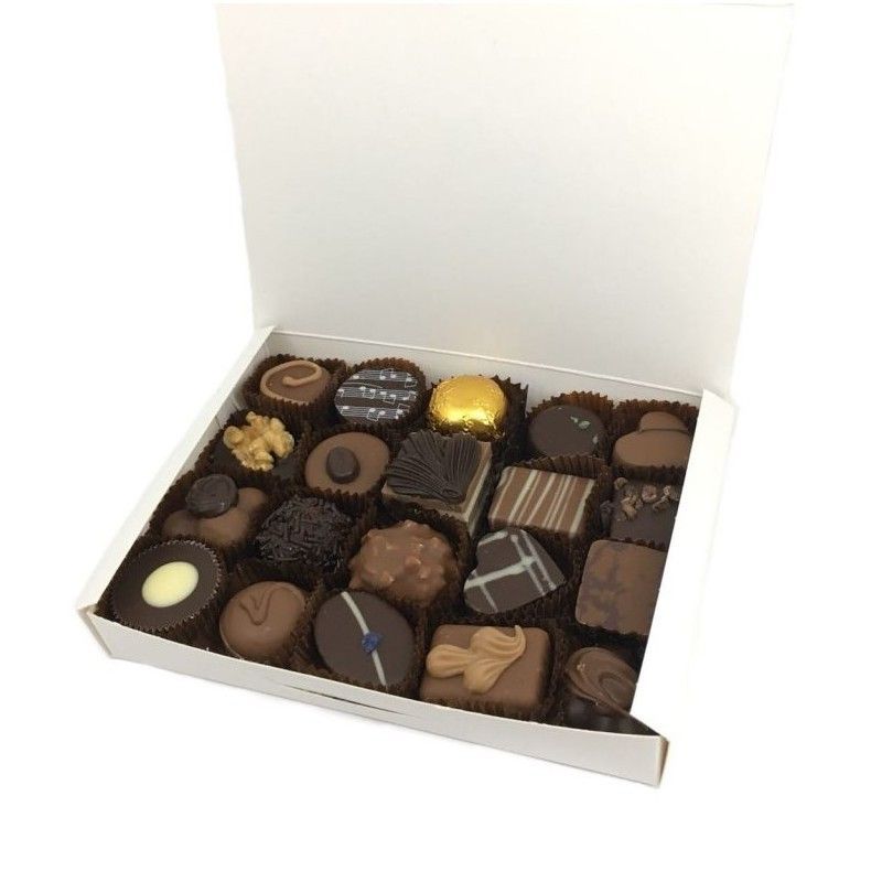 Una caja blanca llena de una variedad de chocolates.