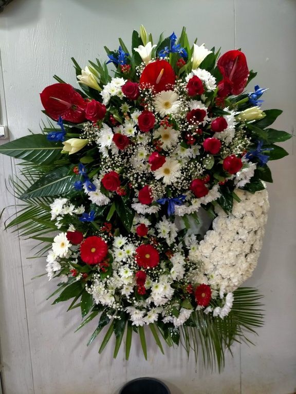 Una gran corona de flores rojas, blancas y azules.