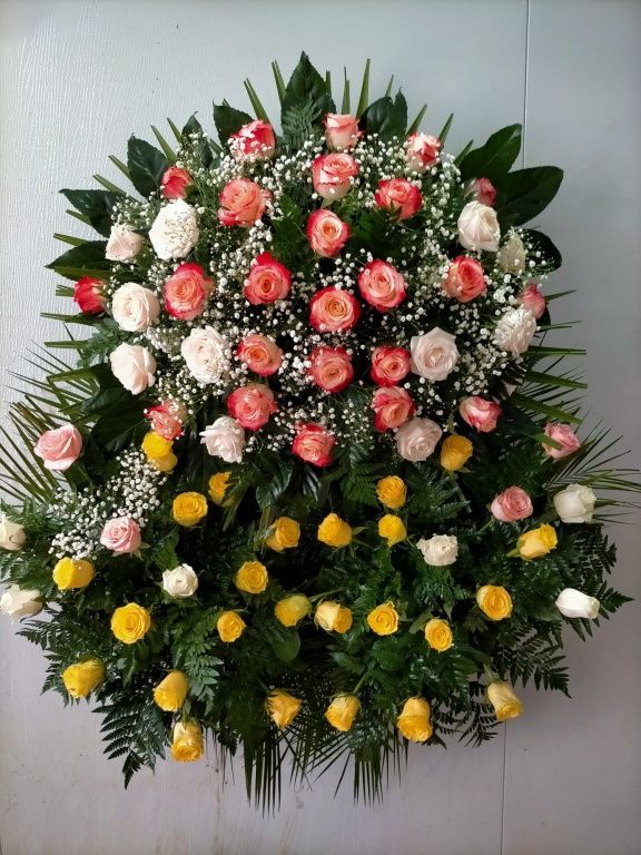 Una corona de rosas rosadas y amarillas y aliento de bebé.