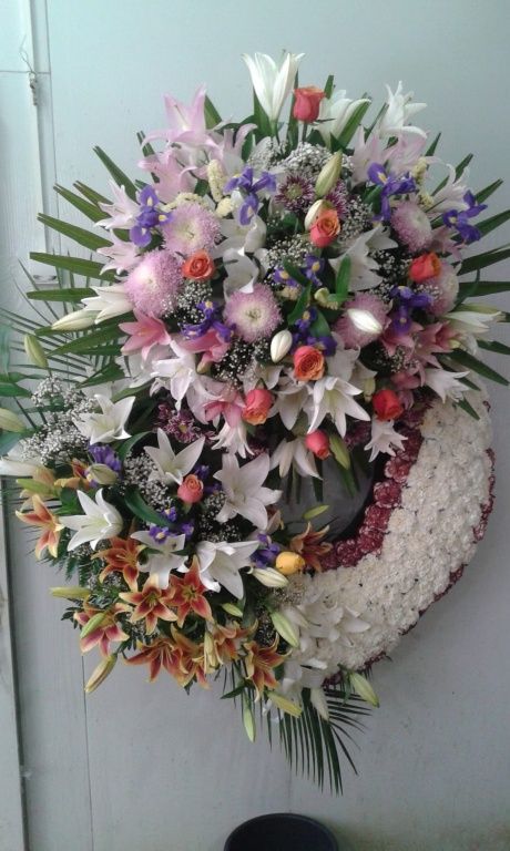 Una gran corona de flores está sobre una mesa.