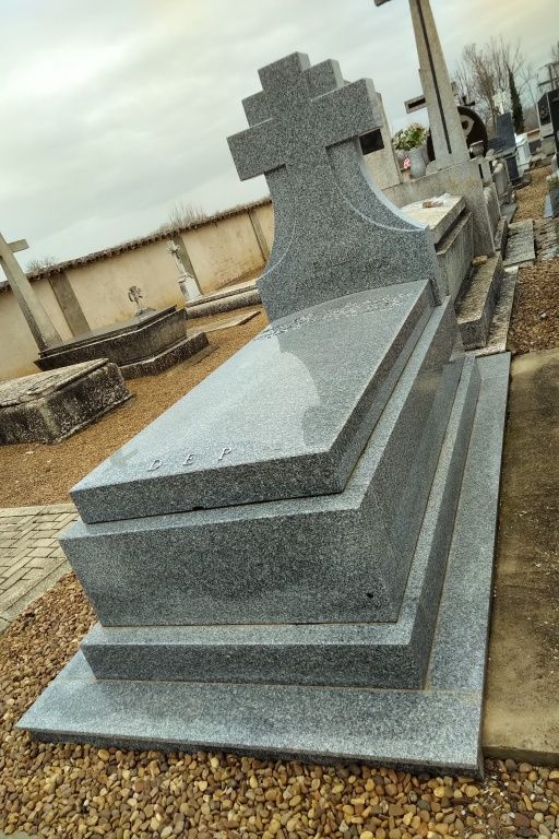 Una tumba con una cruz encima en un cementerio.
