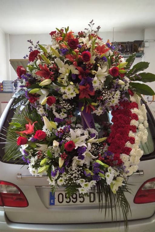 Un coche está decorado con flores en la parte trasera.