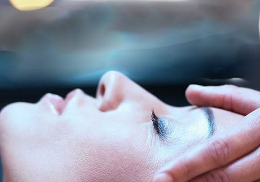 Una mujer está recibiendo un masaje de cabeza en un spa.