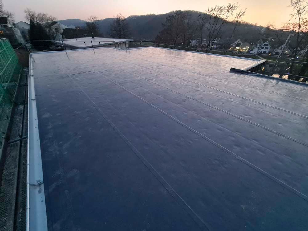 Ein zugefrorener Außenpool spiegelt das sanfte Licht des Sonnenuntergangs wider.