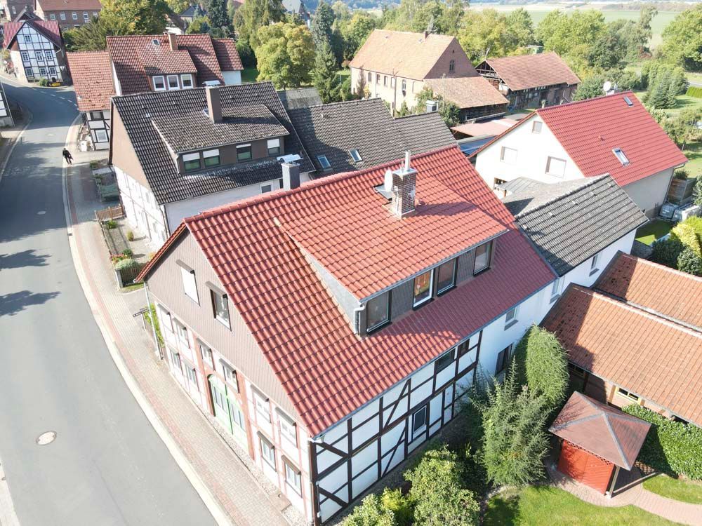 Blick auf ein europäisches Dorf mit Fachwerkhäusern und roten Ziegeldächern.