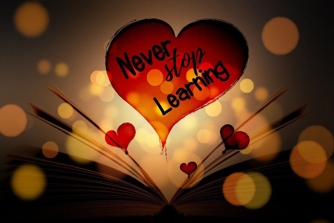 Open book with a glowing heart that says 