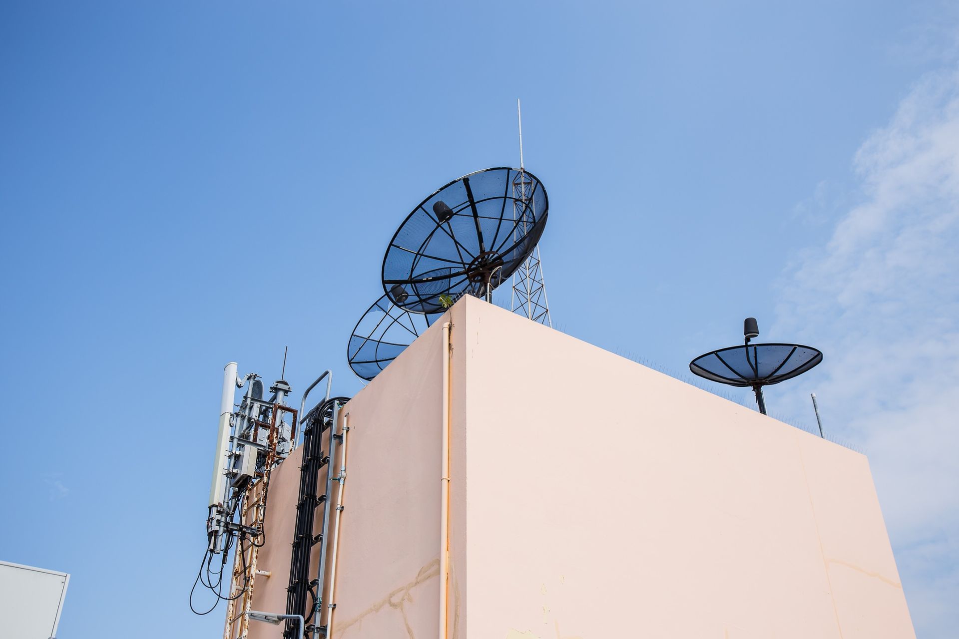 Un edificio con dos antenas parabólicas encima.