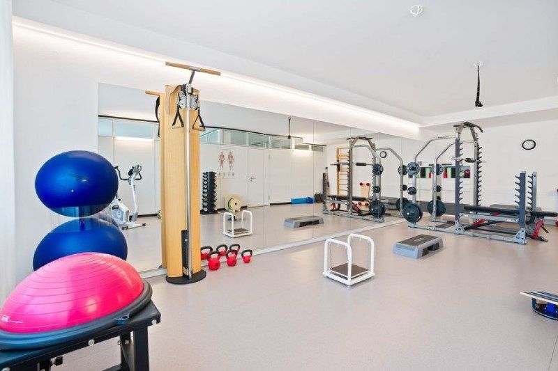 Ein grosser Raum mit vielen Fitness-Geräten und einem grossen Spiegel. Foto von der Physiotherapie Giger GmbH