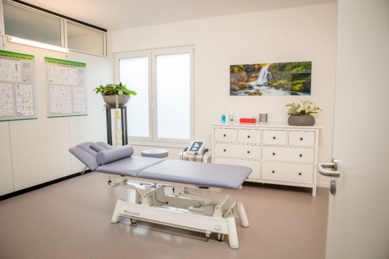 In der Mitte des Zimmers steht ein Behandlungstisch. Foto von der Physiotherapie Giger GmbH