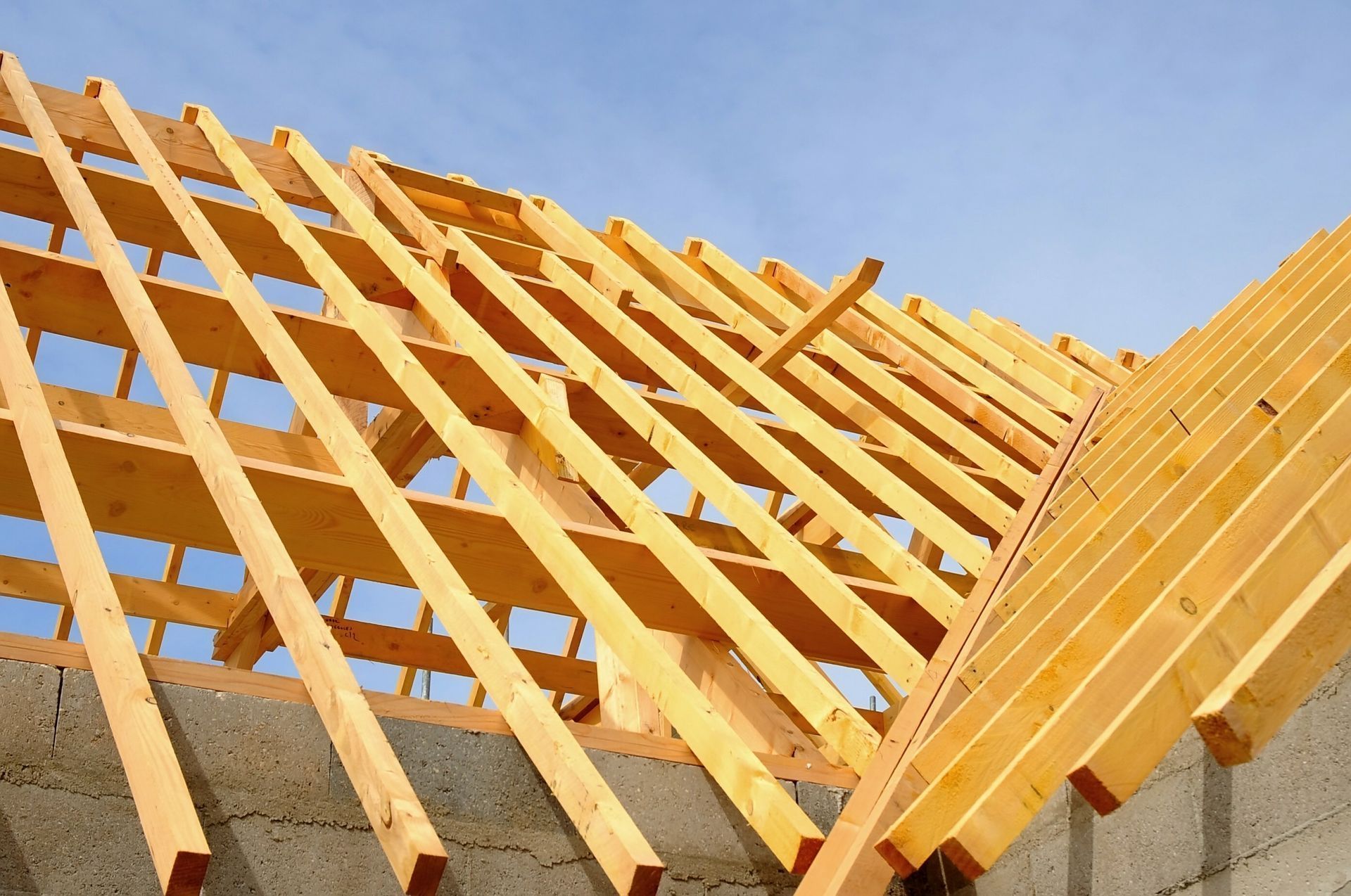 Charpente de toit en bois en construction sur fond de ciel bleu